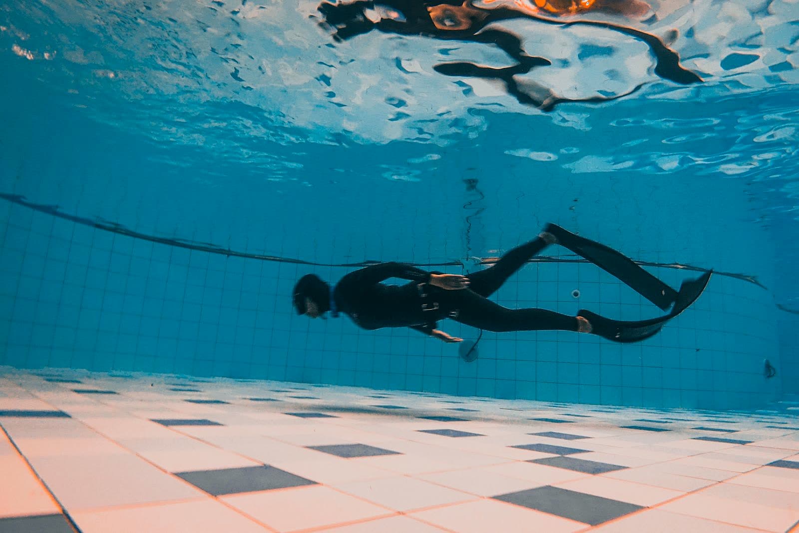 A diver underwater in a swimming pool, illustrative of confined-water training