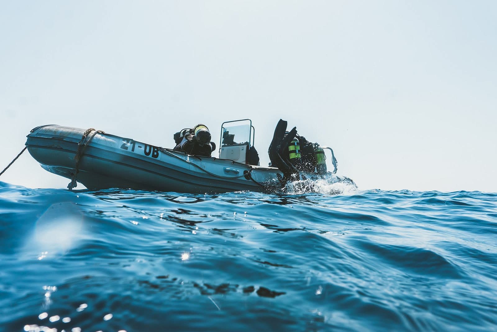 Scuba divers equipped for a dive, preparing from a boat — generic/atmospheric