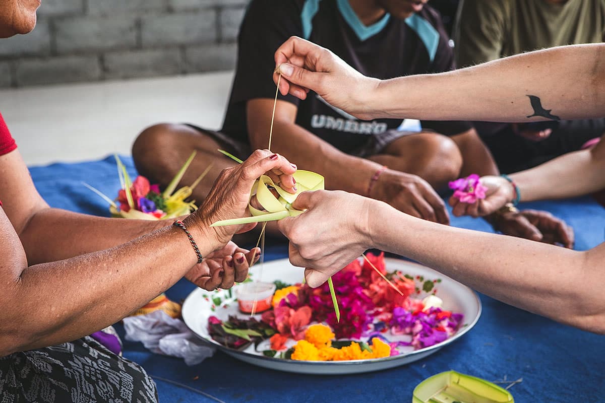 Hands preparing a traditional Balinese offering