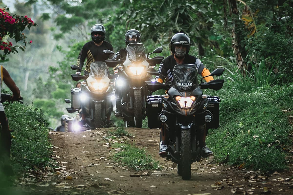 Motorcycle riders on a jungle trail at night