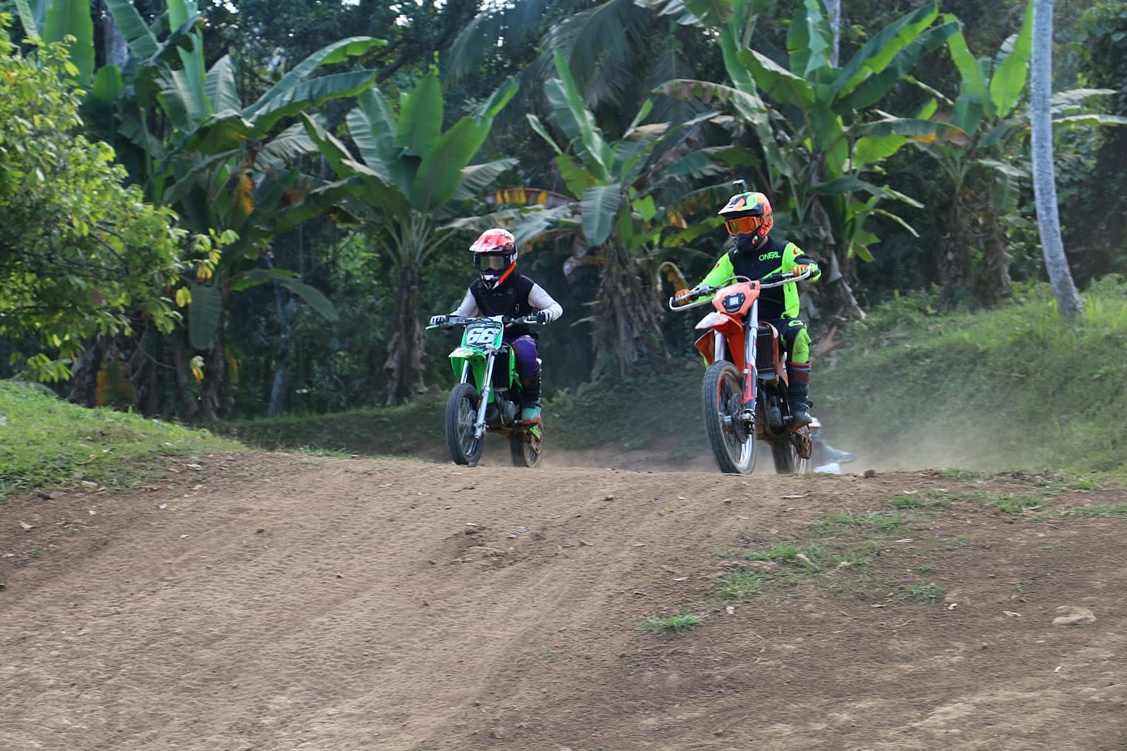 Two motocross riders racing a dirt track in Bali